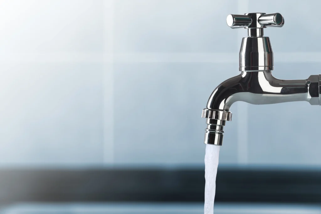Krom banyo bataryası, modern su armatürleri tasarımı ile lavabo üzerinde akan su